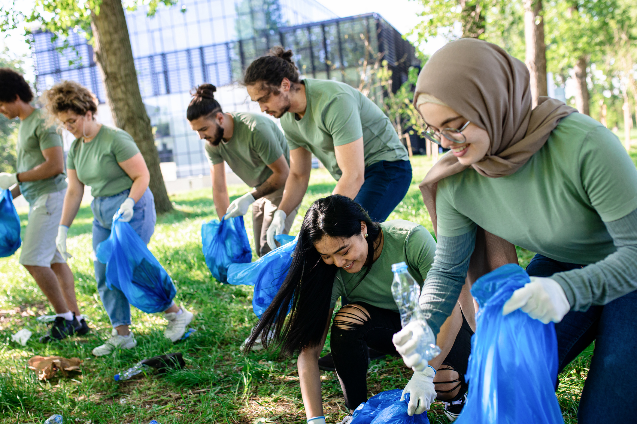 Multiethnic group of volunteers with garbage bags cleaning city park. Multiethnic group of volunteers with garbage bags cleaning city park.