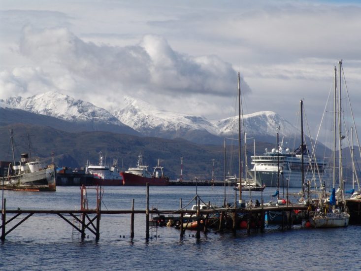 Snow-capped Andes peaks overlook the Ushuaia waterfront, a popular cruise ship port. Ushuaia Argentina.
