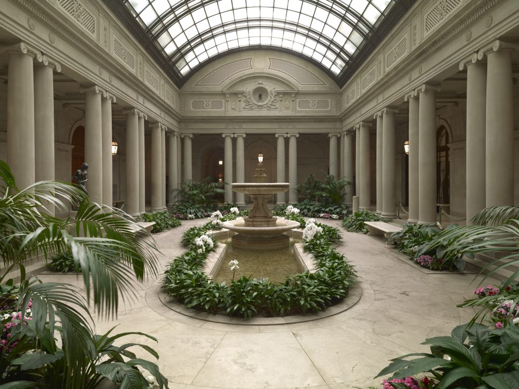The Garden Court was designed by John Russell Pope to replace the open carriage court of the original Frick residence. The Court's paired Ionic columns and symmetrical planting beds were echoed in Pope's later designs for the original building of the National Gallery of Art in Washington, D.C.