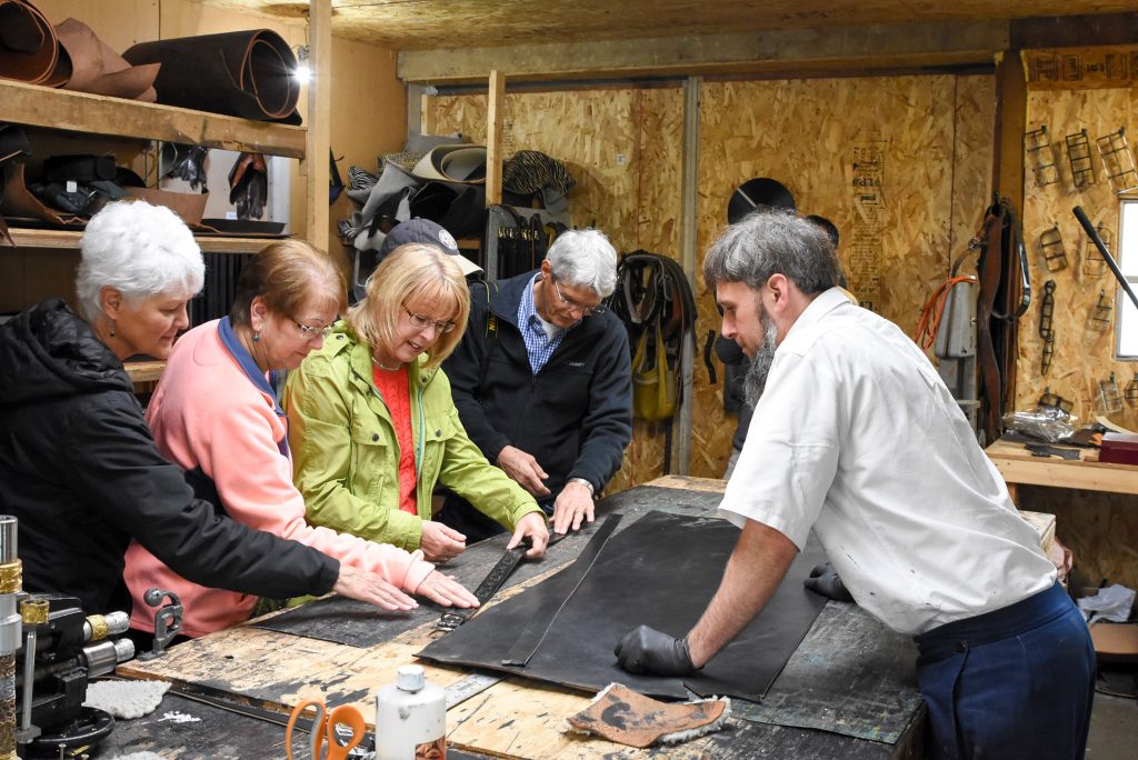 Loren Yoder, owner of Silver Star Leather in Shipshewana, shows tourists how he makes belts from cowhide and exotic leathers like ostrich and alligator. (Photo credit: Blue Gate Hospitality)