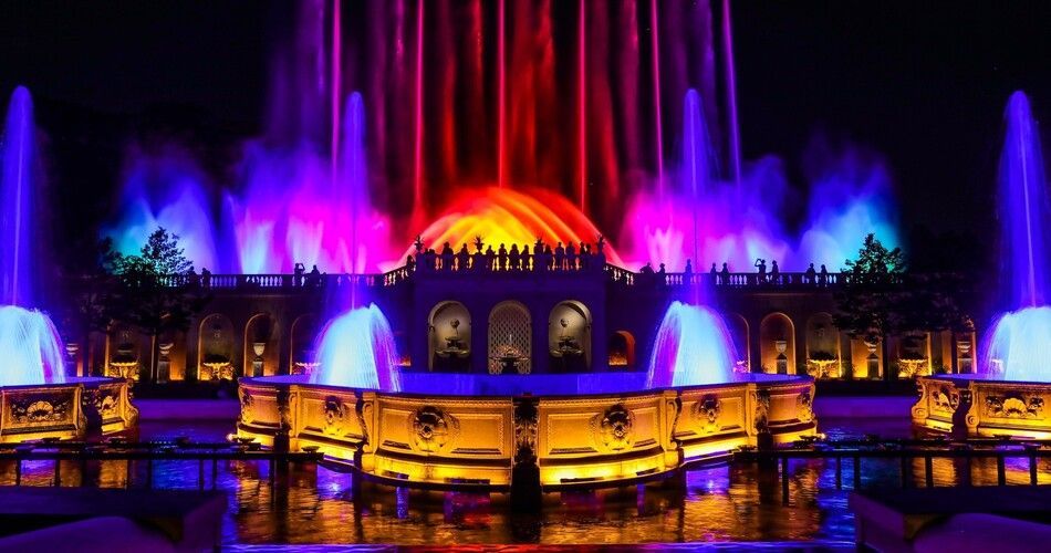 Fountains are illuminated at night.