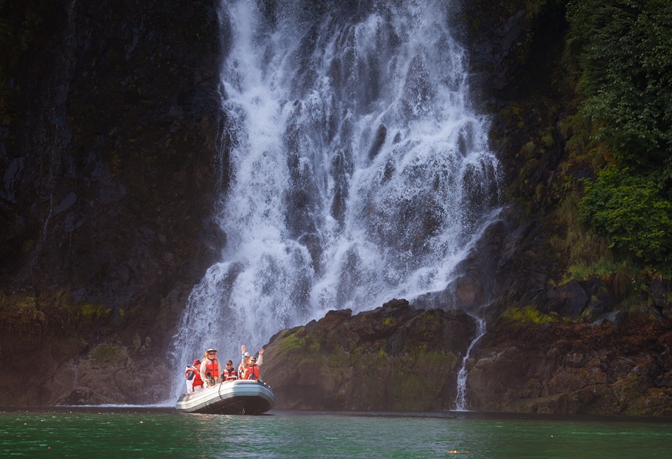Skiff ride in front of waterfall Red Bluff Bay