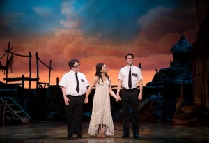 Cody Jamison Strand as Elder Cunningham, Kim Exum as Nabulungi, Dave Thomas Brown as Elder Price in The Book of Mormon